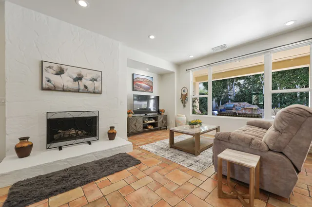 a living room with furniture a large window and a fireplace