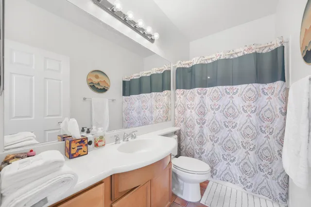 a bathroom with a sink a toilet and a shower curtain