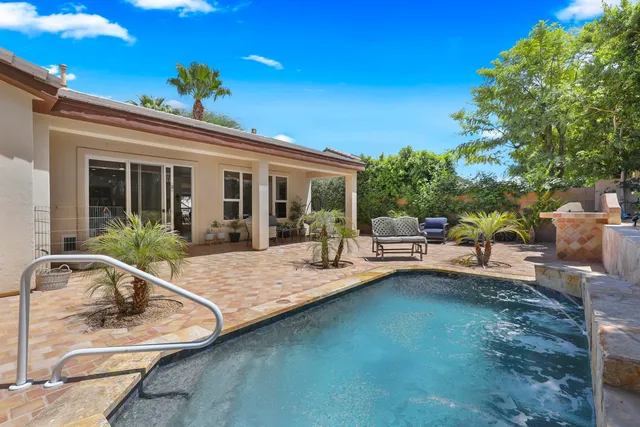 a view of a house with swimming pool and sitting area