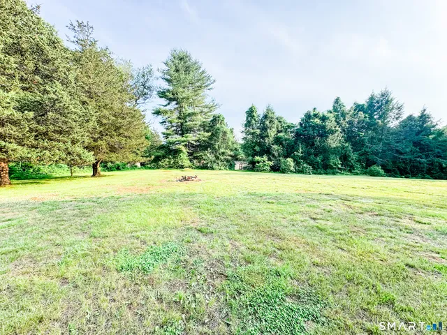 a view of a field with an trees in the background