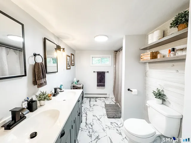 a bathroom with a sink a toilet and shower