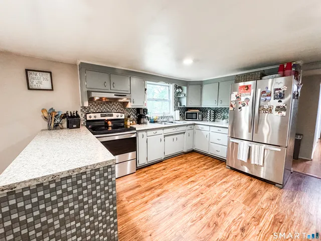a kitchen with a sink a refrigerator and cabinets