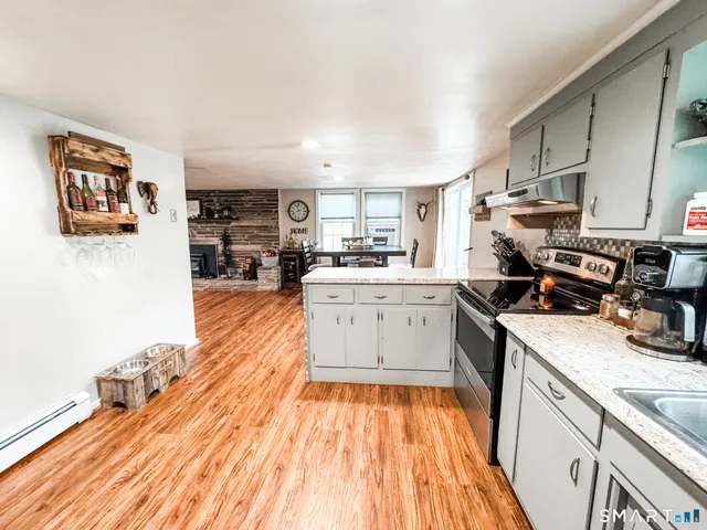 a kitchen with cabinets wooden floor and stainless steel appliances