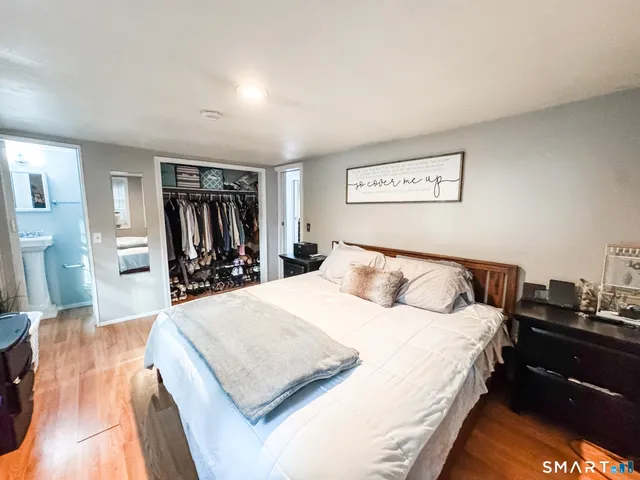 a large bedroom with a bed and wooden floor