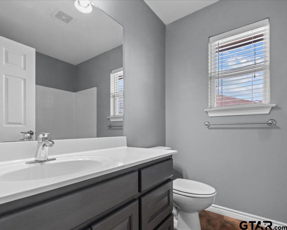 11230 Triple Crown Drive Flint, TX 75762 - Photo 18 of 19 a bathroom with a sink a toilet a mirror and vanity