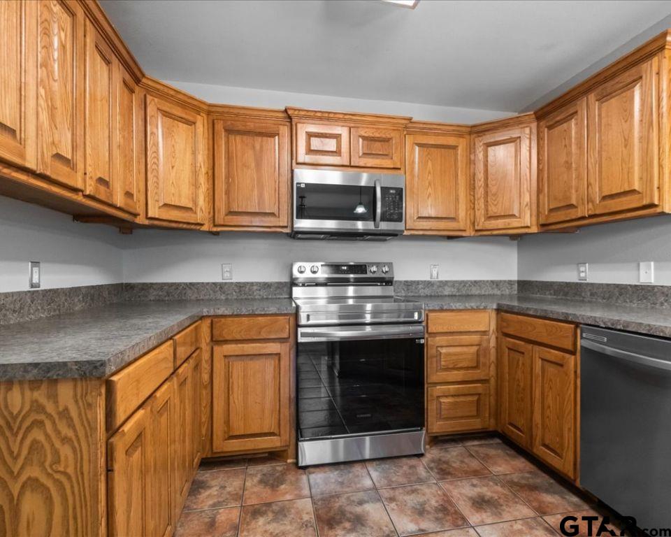 11230 Triple Crown Drive Flint, TX 75762 - Photo 9 of 19 a kitchen with stainless steel appliances granite countertop a stove sink microwave and cabinets
