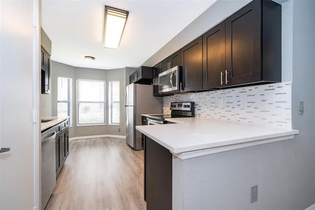 a kitchen with stainless steel appliances a sink stove and refrigerator