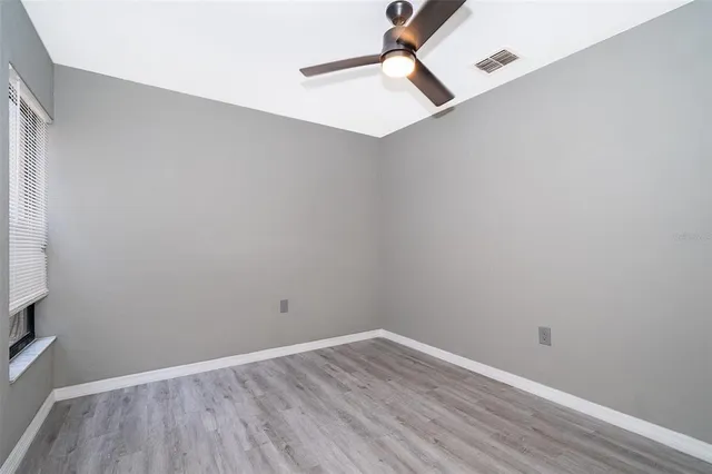 a view of a room with wooden floor and a ceiling fan
