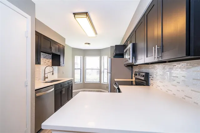 a kitchen with granite countertop a sink a stove and cabinets