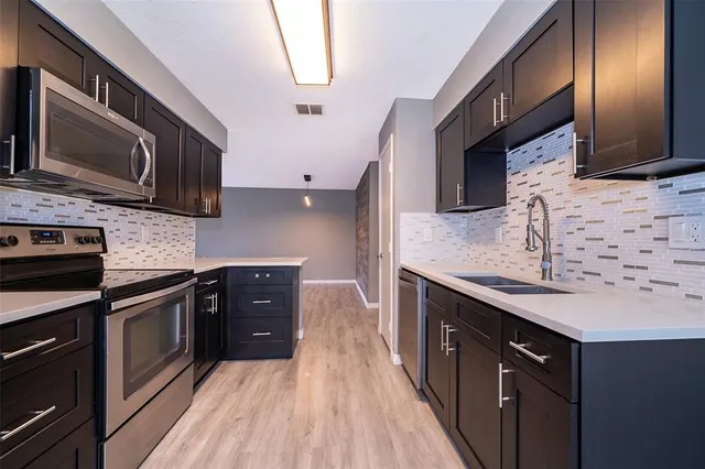 a kitchen with stainless steel appliances granite countertop a sink stove and microwave