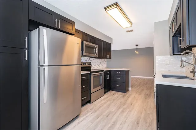 a kitchen with stainless steel appliances a refrigerator and a sink