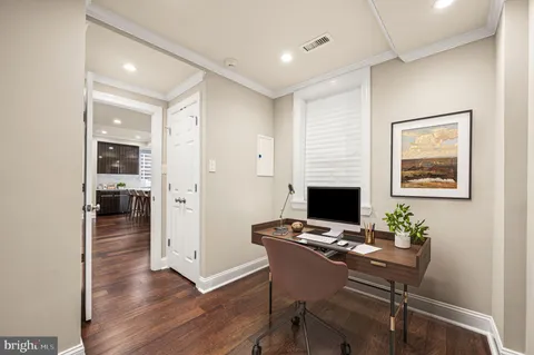 a view of a workspace with furniture and wooden floor