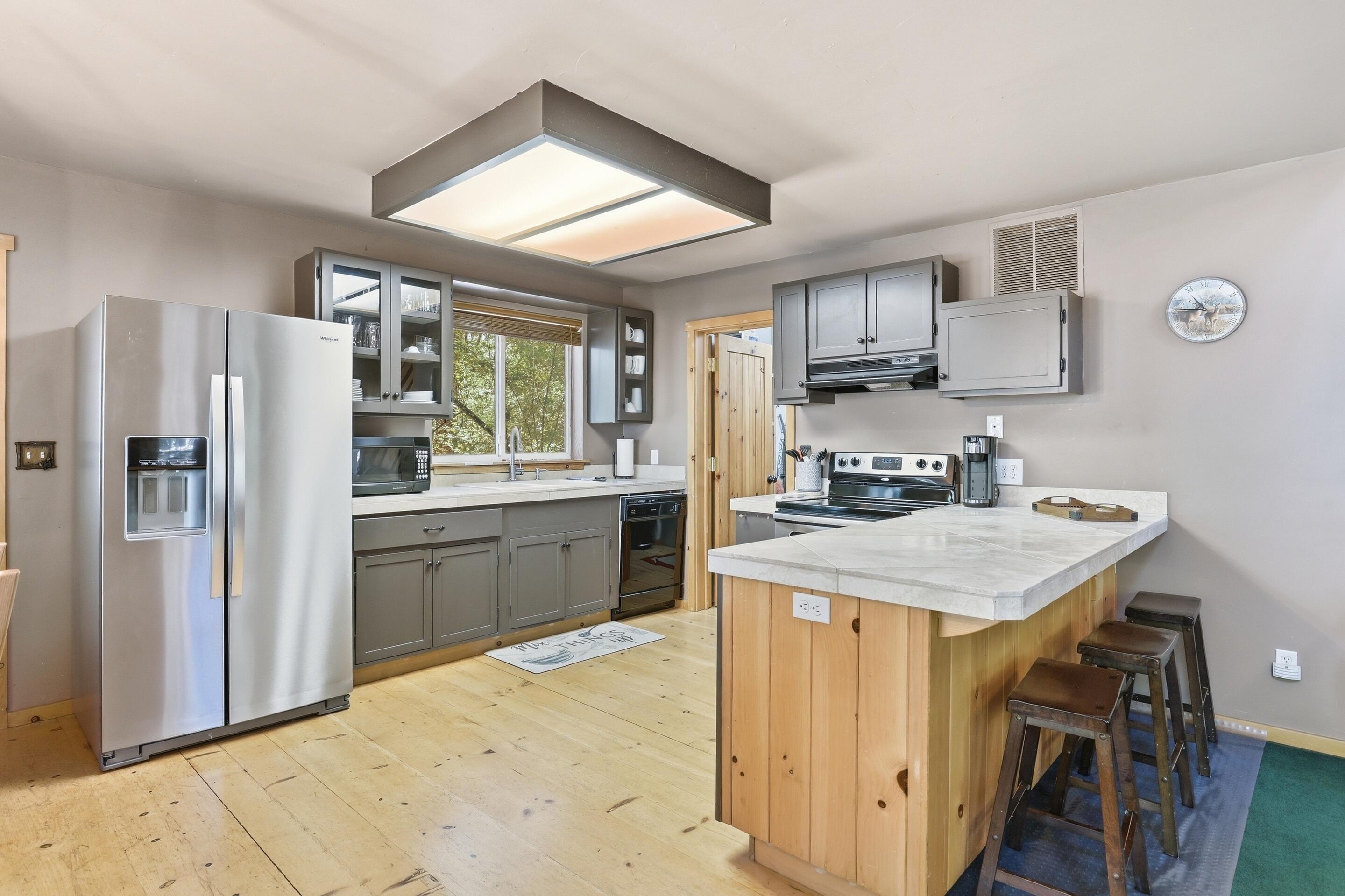 6322 Sharyn Road Pine, AZ 85544 - Photo 12 of 37 a kitchen with stainless steel appliances granite countertop a refrigerator a sink dishwasher a stove and white countertops with wooden floor