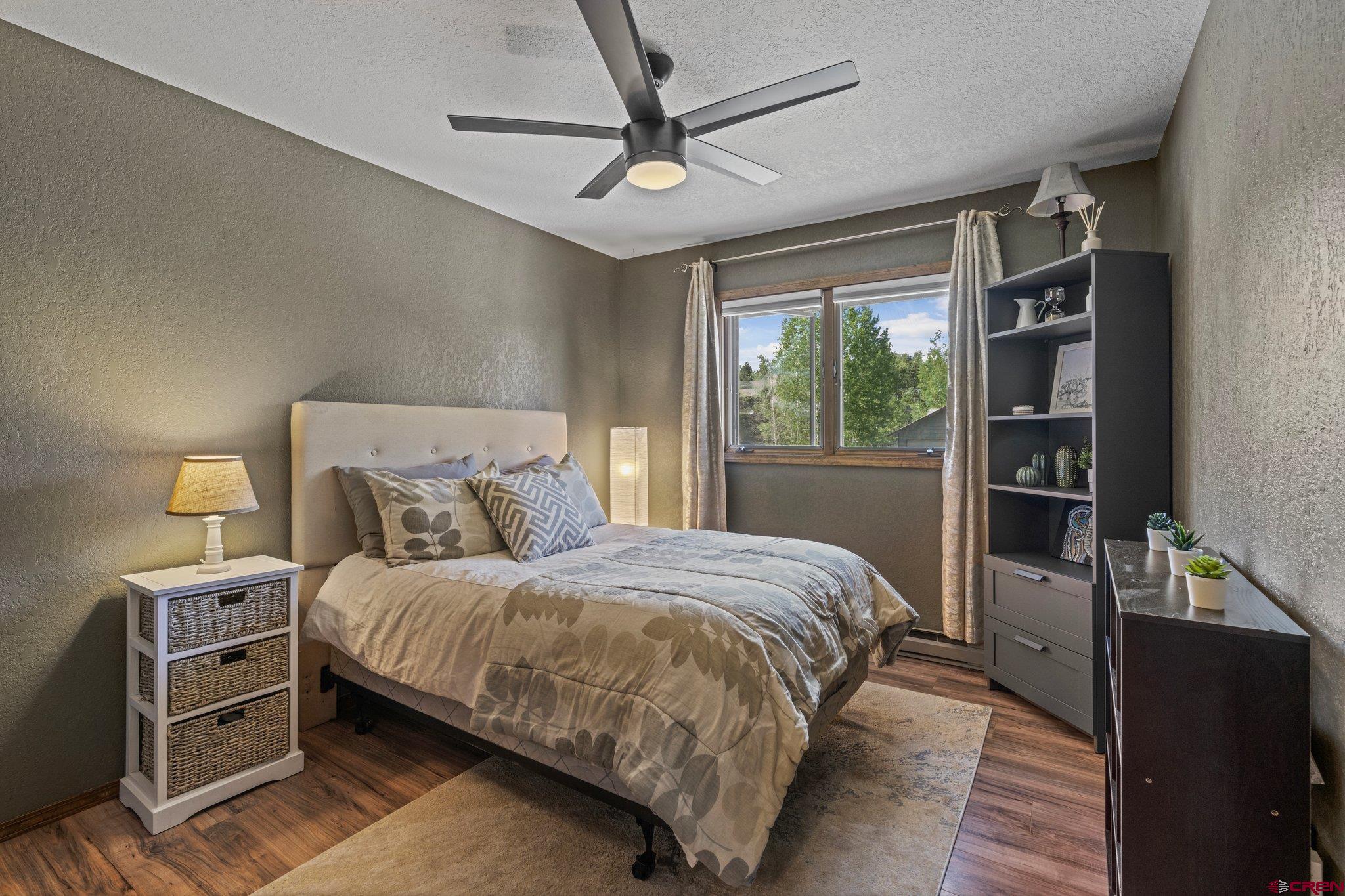 238 Pine Ridge Loop, Unit A1 Durango, CO 81301 - Photo 18 of 35 a bedroom with a bed and a flat tv screen on dresser