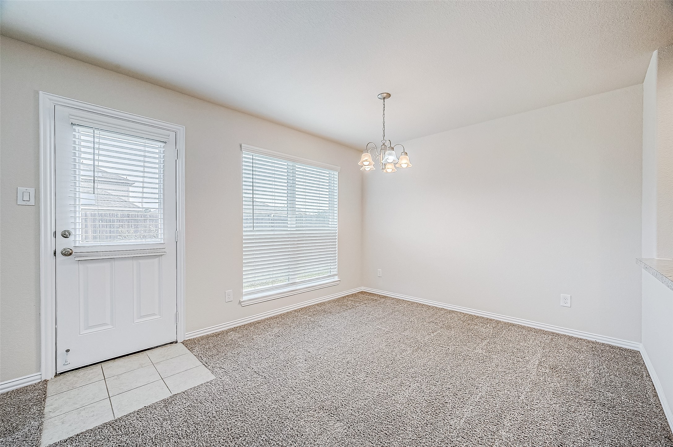 3406 Water Lilly Way Richmond, TX 77469 - Photo 13 of 44 an empty room with chandelier fan and windows