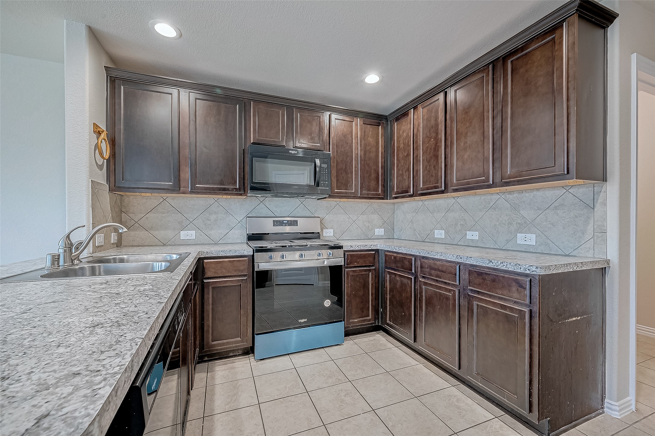 3406 Water Lilly Way Richmond, TX 77469 - Photo 16 of 44 a kitchen with stainless steel appliances granite countertop a sink stove microwave and cabinets