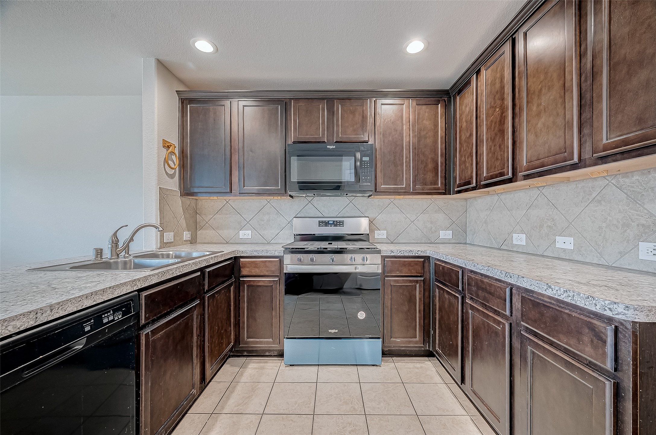 3406 Water Lilly Way Richmond, TX 77469 - Photo 17 of 44 a kitchen with a sink stove top oven and cabinets