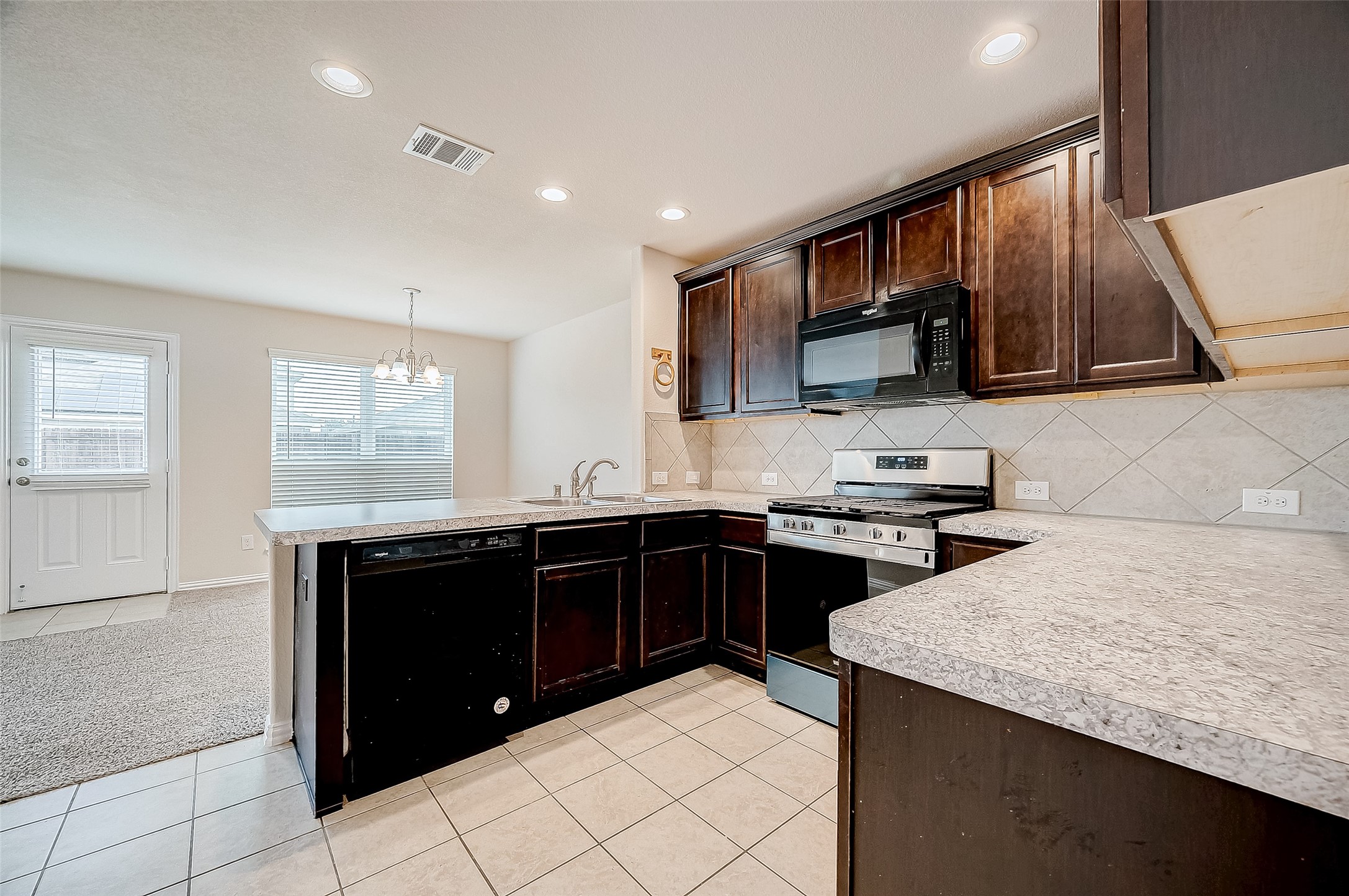 3406 Water Lilly Way Richmond, TX 77469 - Photo 18 of 44 a kitchen with a sink and a stove top oven with wooden floor