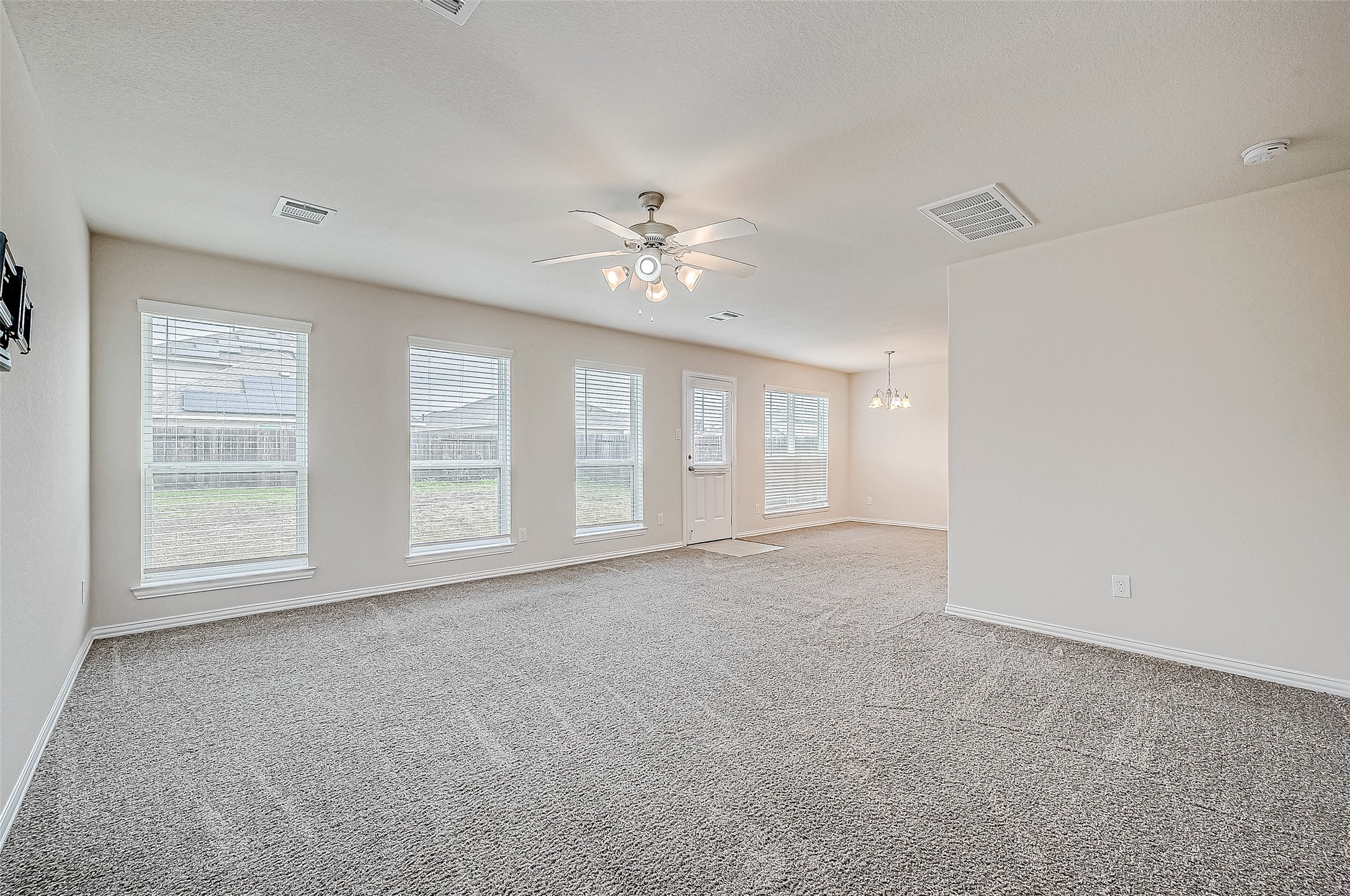 3406 Water Lilly Way Richmond, TX 77469 - Photo 9 of 44 an empty room with chandelier fan and windows