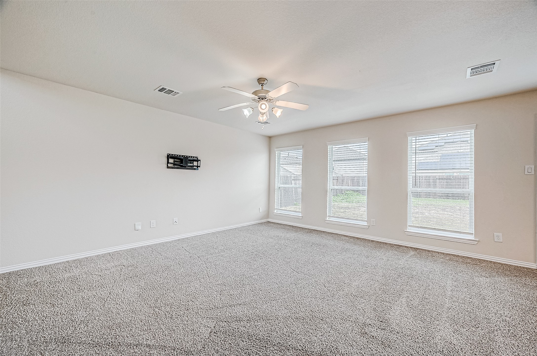 3406 Water Lilly Way Richmond, TX 77469 - Photo 10 of 44 an empty room with chandelier fan and windows