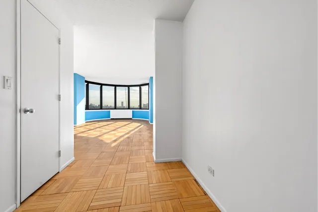 a bedroom with a bed couch and a large window