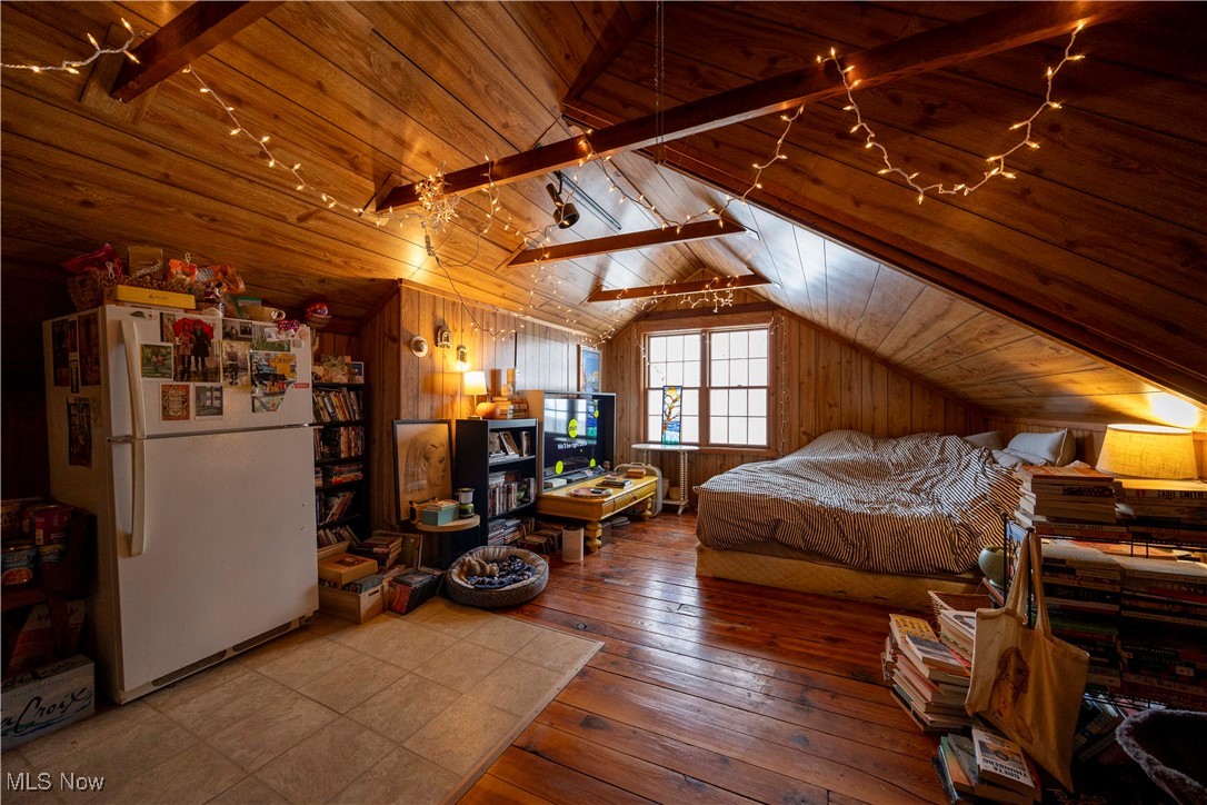2075 Coventry Road Cleveland, OH 44118 - Photo 26 of 41 Bedroom with wood ceiling, wooden walls, lofted ceiling with beams, and white refrigerator