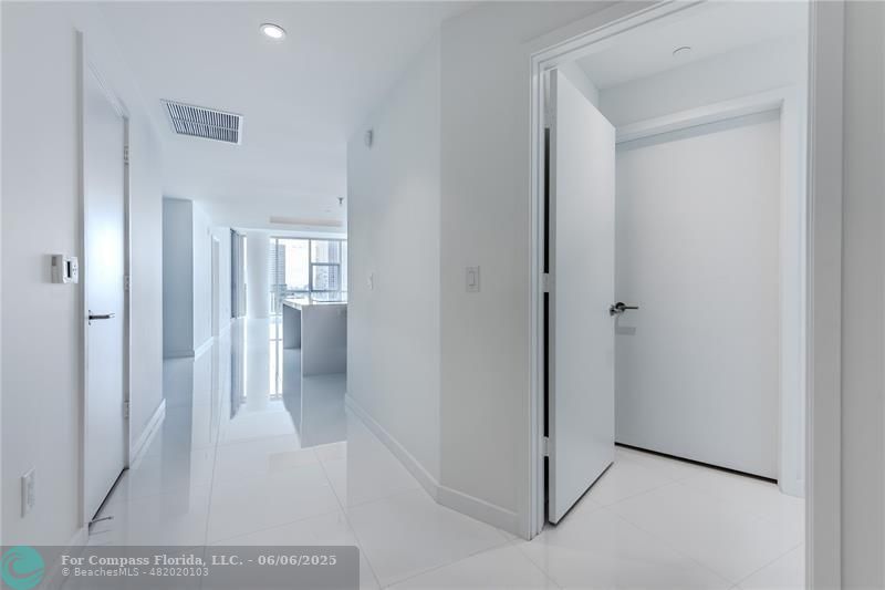 851 Northeast 1st Avenue, Unit 1912 Miami, FL 33132 - Photo 15 of 26 a view of a hallway with wooden floor and a bathroom