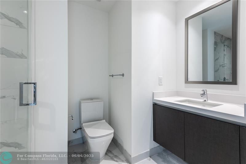 851 Northeast 1st Avenue, Unit 1912 Miami, FL 33132 - Photo 21 of 26 a bathroom with a toilet sink and mirror
