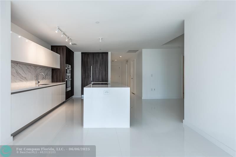 851 Northeast 1st Avenue, Unit 1912 Miami, FL 33132 - Photo 3 of 26 a view of kitchen with refrigerator and white cabinets