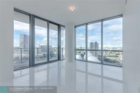 a view of a hallway with wooden floor and a bathroom