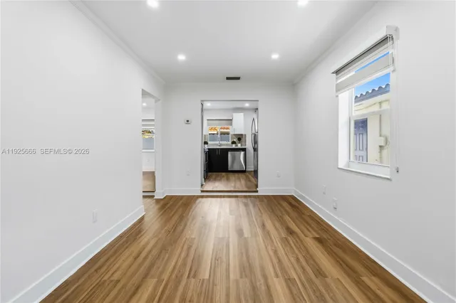 a view of a hallway with wooden floor and a window
