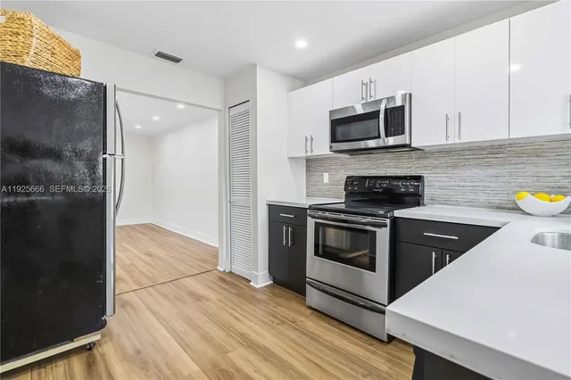 a kitchen with stainless steel appliances a stove a microwave and cabinets