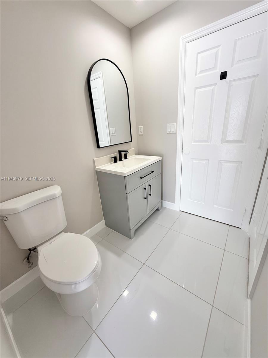 20530 Southwest 316th Street, Unit A Homestead, FL 33030 - Photo 2 of 7 a bathroom with a toilet sink and mirror