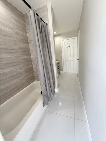 an empty room with windows and ceiling fan