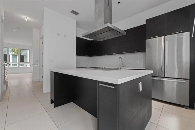a kitchen with stainless steel appliances a refrigerator and a stove top oven