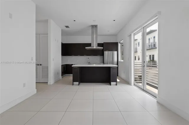an empty room with wooden floor & window and cabinet