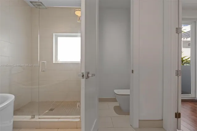 a view of an empty room with wooden floor and closet