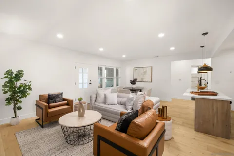 a living room with furniture a chandelier and a table