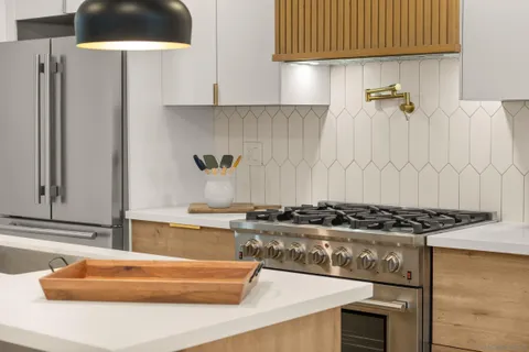 a kitchen with stainless steel appliances granite countertop a sink a stove and a refrigerator