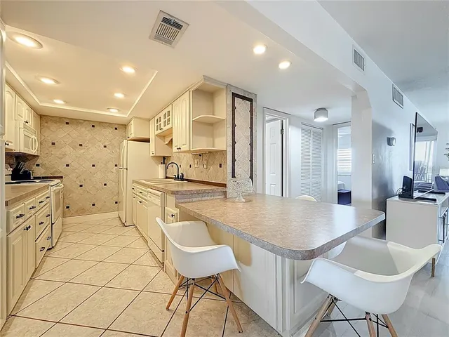a kitchen with white cabinets and white appliances