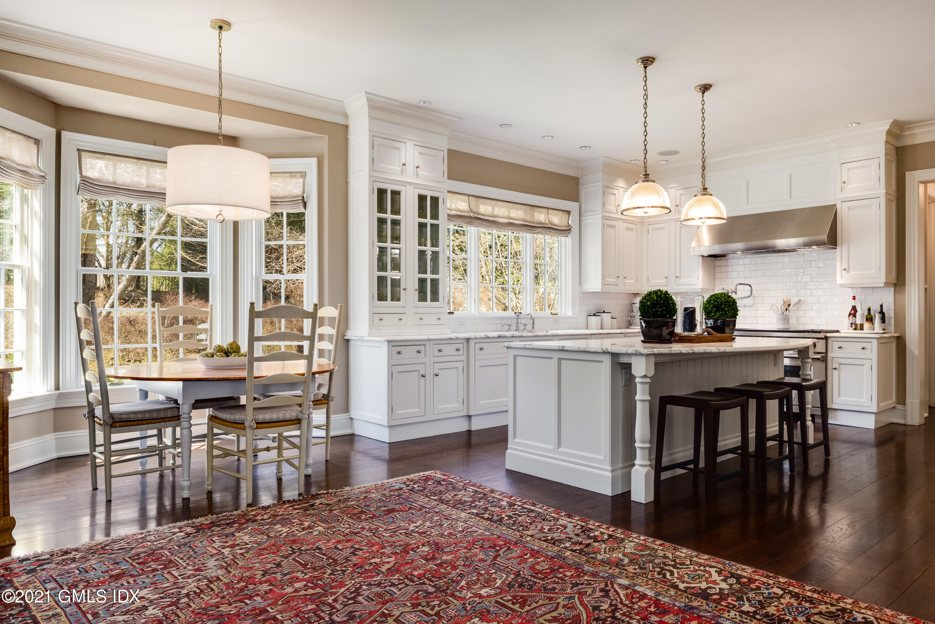 94 Doubling Road Greenwich, CT 06830 - Photo 10 of 26 a kitchen with kitchen island granite countertop a stove a sink a dining table and chairs with wooden floor