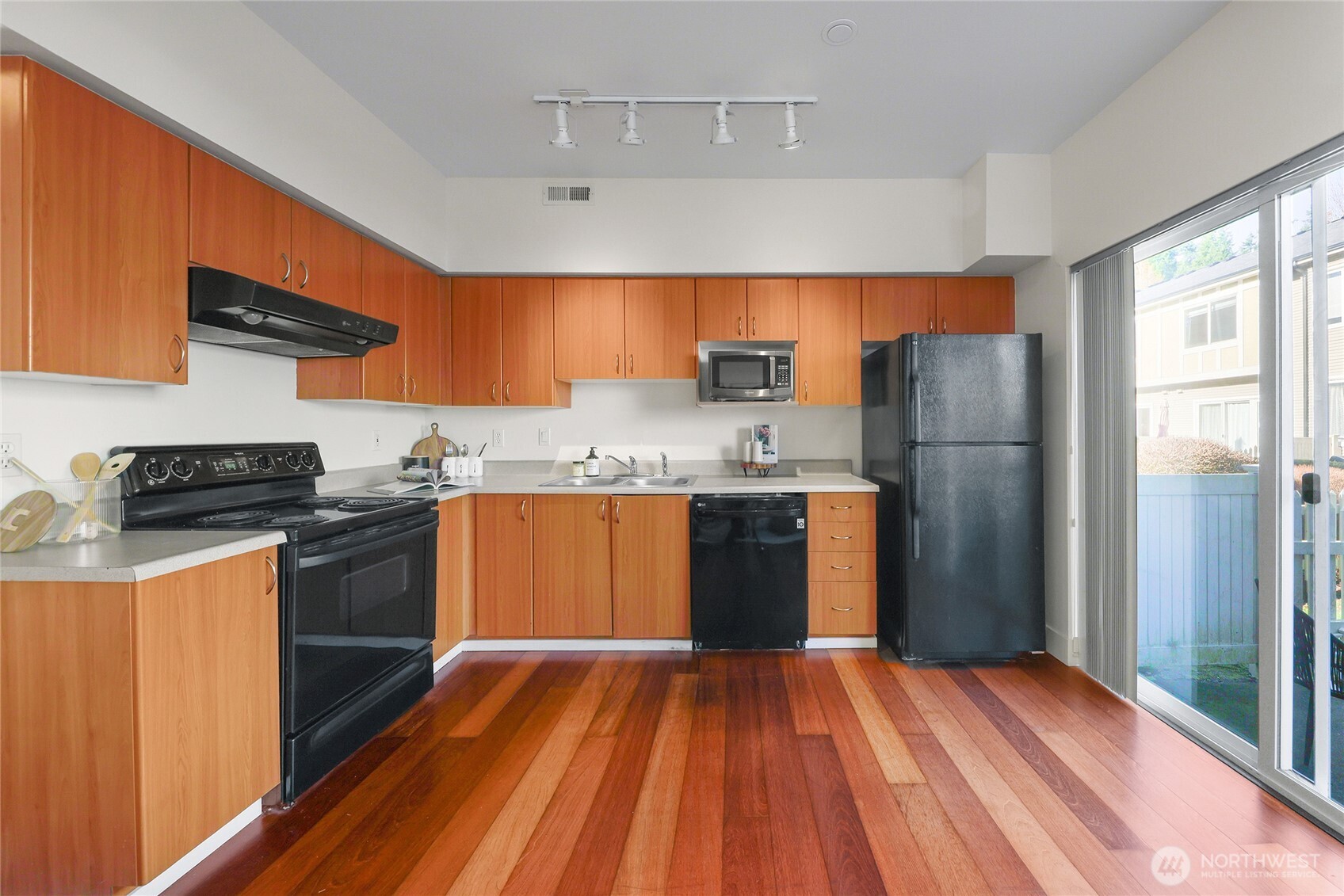 18258 Northeast 96th Way, Unit 101 Redmond, WA 98052 - Photo 12 of 36 a kitchen with a refrigerator and wooden cabinets