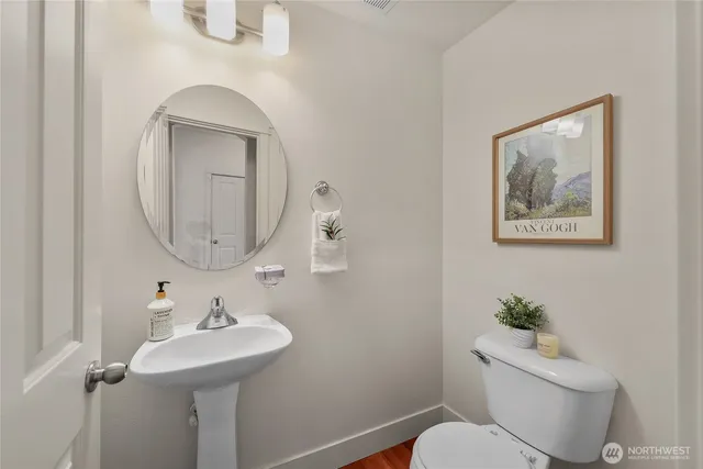 a bathroom with a toilet a sink and mirror