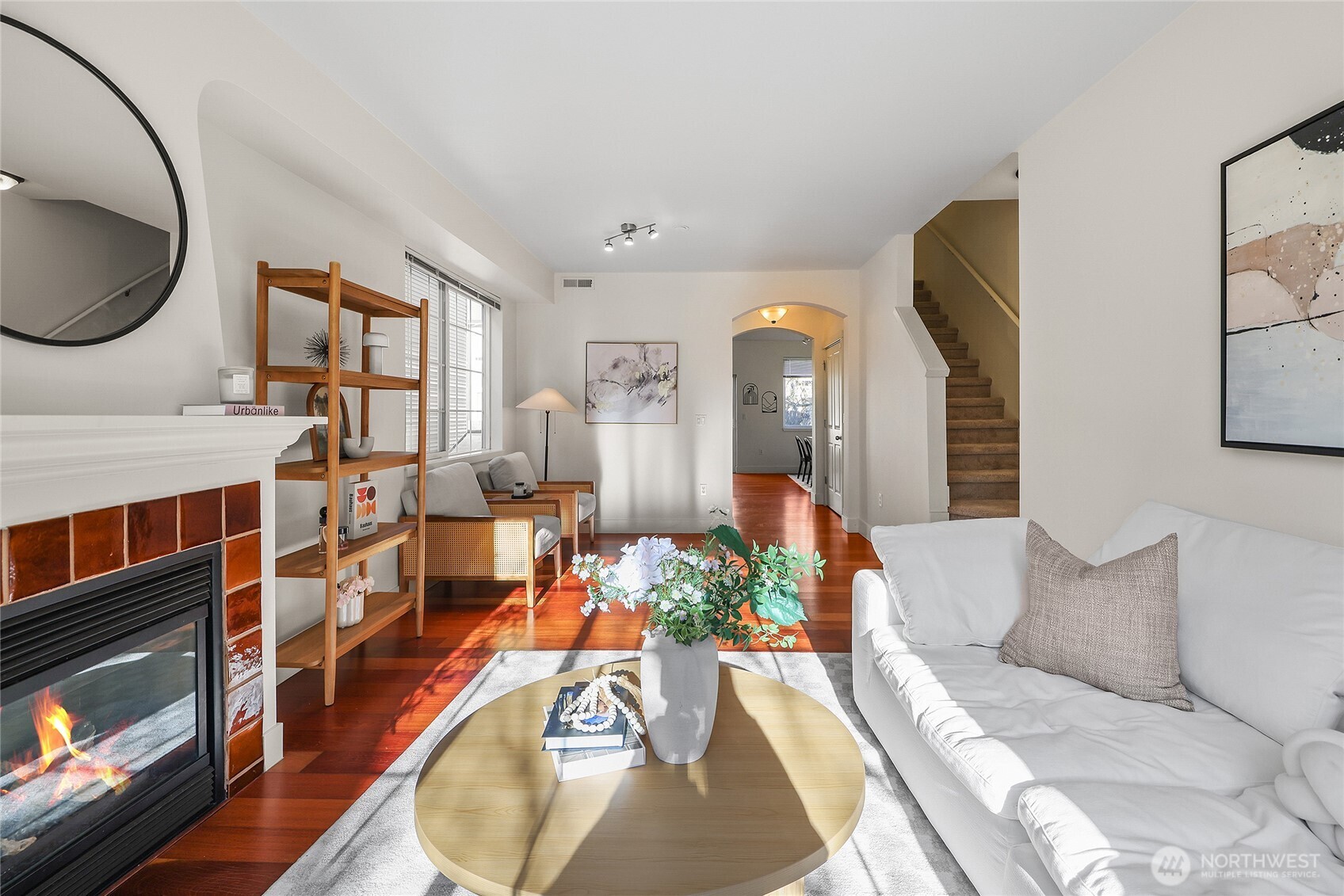 18258 Northeast 96th Way, Unit 101 Redmond, WA 98052 - Photo 4 of 36 a living room with furniture a mirror and a fireplace