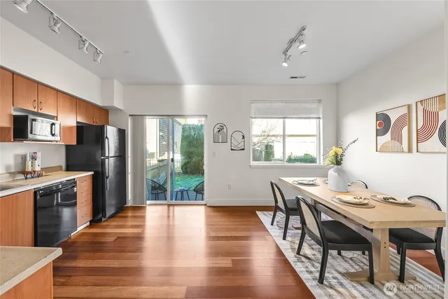 a kitchen with stainless steel appliances granite countertop a stove a refrigerator a kitchen island a table and chairs in it