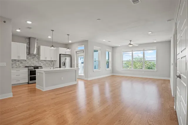 a large kitchen with stainless steel appliances granite countertop a lot of counter space and wooden floor