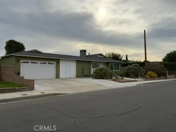 a front view of a house with a garden and parking