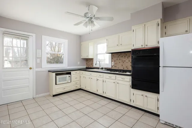 a kitchen with white cabinets and white appliances