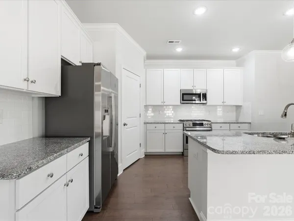 a kitchen with stainless steel appliances granite countertop a refrigerator sink and stove