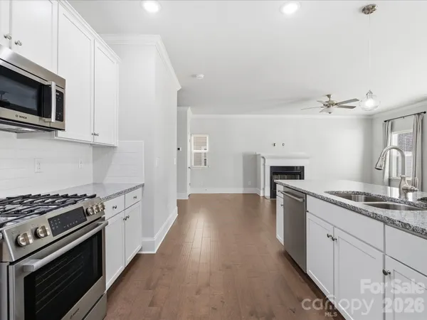 a kitchen with granite countertop a stove top oven and sink